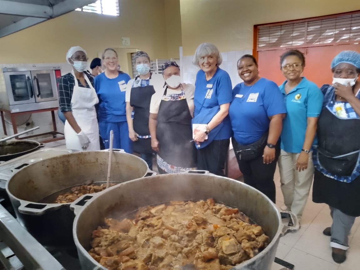 Volunteers cooking large pots of food for Futuro Vivo students